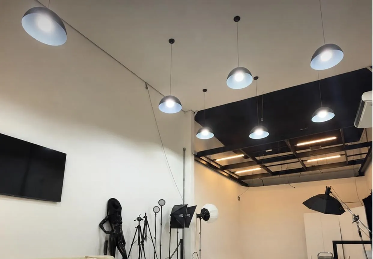 Interior do DJOO Studio com luminárias pendentes e equipamentos de iluminação