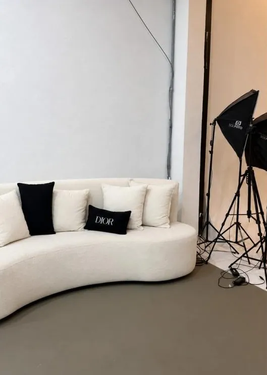 Sofá curvo off-white com almofadas pretas